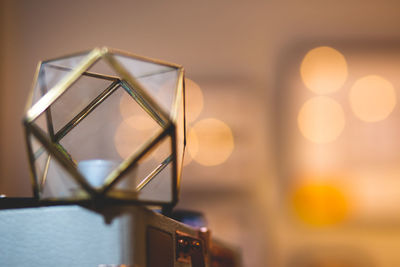 Close-up of illuminated lamp on table against sky at sunset