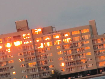 Illuminated city against sky at night