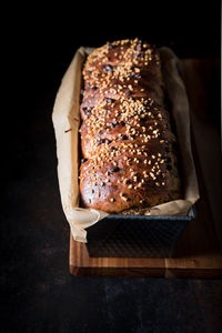 High angle view of bread in container on table against black background