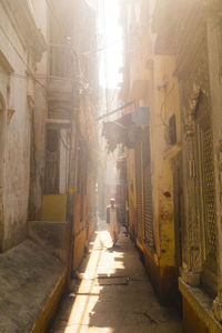 Woman on cobblestone street amidst buildings