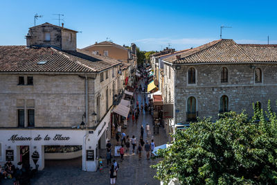 People on street amidst buildings in city