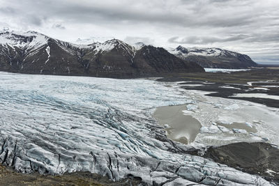 Scenic view of mountains and glacier against sky