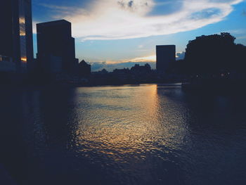 Reflection of buildings in river at sunset