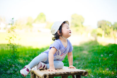 Full length of boy sitting on field