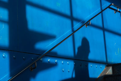The shadow of a man on a blue surface