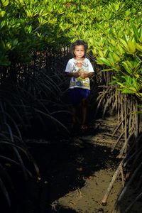 Portrait of woman standing against plants