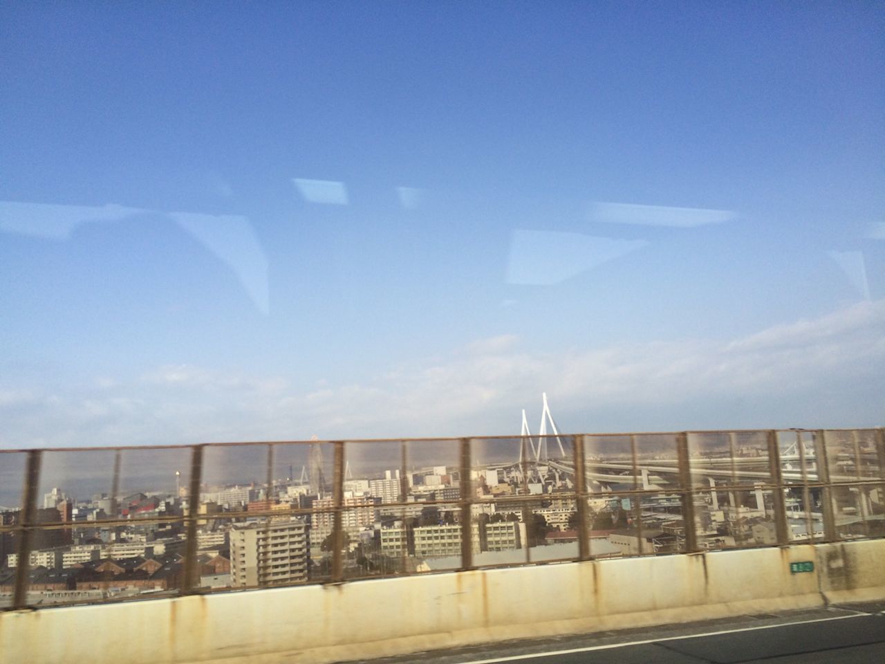 transportation, sky, blue, built structure, railing, architecture, road, copy space, building exterior, city, connection, clear sky, outdoors, bridge - man made structure, day, mode of transport, no people, road marking, travel, public transportation