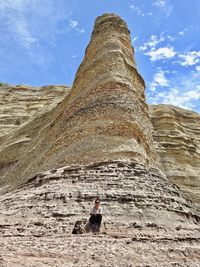 Low angle view of man on rock against sky