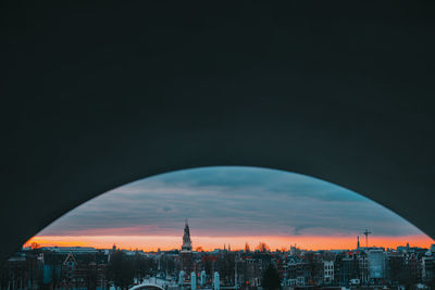 Buildings in city against sky during sunset