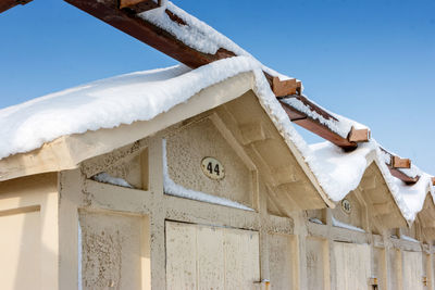 Low angle view of icicles on roof of building against sky