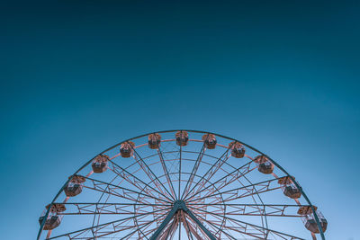 Low angle view of ferris wheel against blue sky