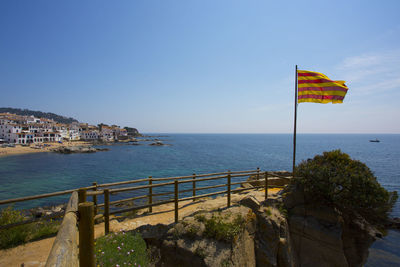 Scenic view of sea and buildings against clear blue sky