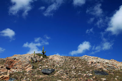 Low angle view of rock against blue sky