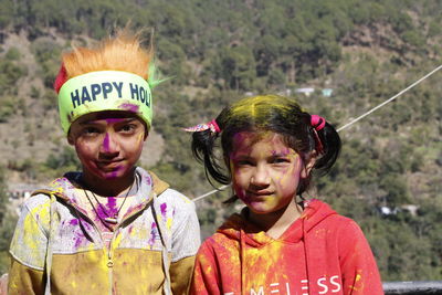 Portrait of siblings with face paint outdoors