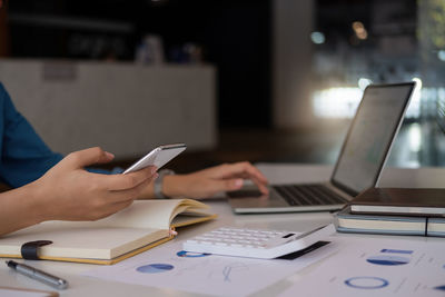 Midsection of man using laptop on table