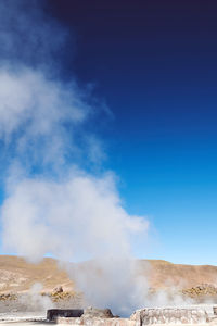 Panoramic view of geyser releasing steam on a volcano