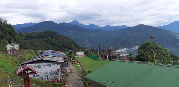 Scenic view of mountains and houses against sky