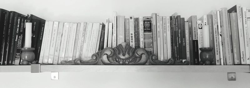 Close-up of statue on books in shelf