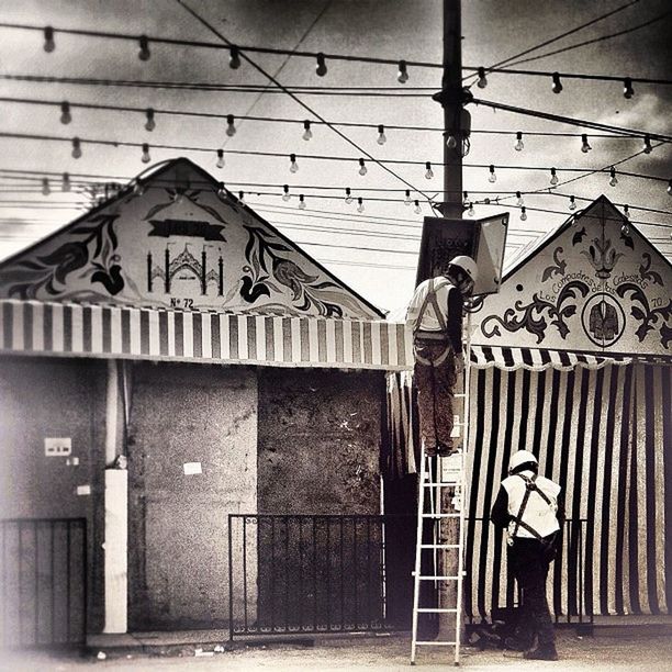 architecture, built structure, building exterior, text, wall - building feature, graffiti, communication, low angle view, western script, no people, outdoors, wall, day, electricity, door, cable, gate, pole, closed, cross