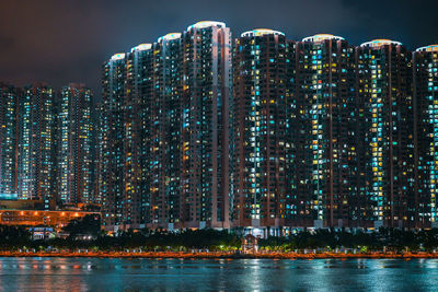 Illuminated buildings against sky at night