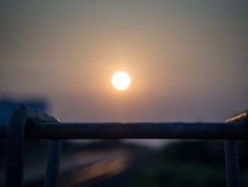 Close-up of railing against sky during sunset