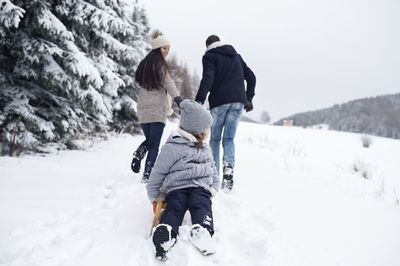 Family with sledge in winter landscape