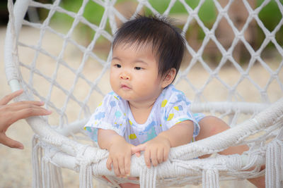 Portrait of cute baby girl in fence