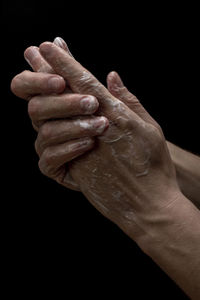 Close-up of hand over black background