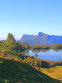 Scenic view of lake against clear blue sky