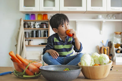 Portrait of boy eating food at home