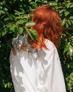 Rear view of woman standing by plants