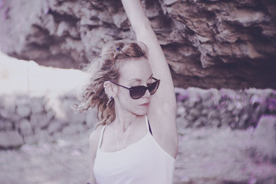 Woman wearing sunglasses under rock