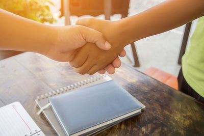 Close-up of hand holding book on table