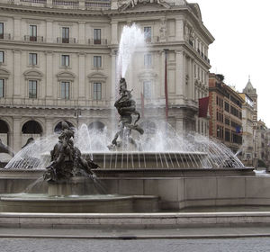 Fountain against building in city