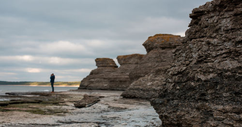 People standing on cliff at seaside