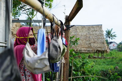 Rear view of woman hanging outside building