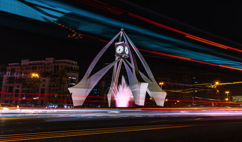 Light trails on road against buildings at night