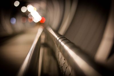 Close-up of railing in illuminated tunnel