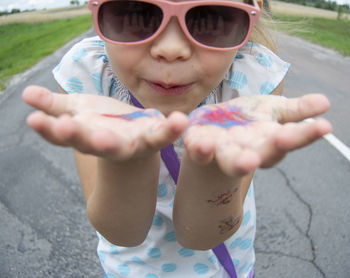 Portrait of cute girl wearing sunglasses on road