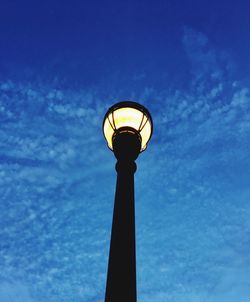 Low angle view of illuminated street light against blue sky