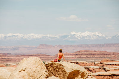 Full length of man standing on rock against sky