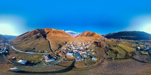 Panoramic view of landscape and mountains against blue sky