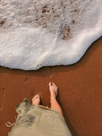 Low section of woman standing on beach