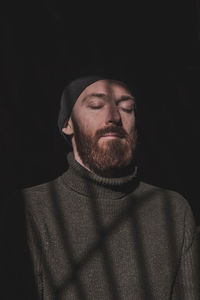 Portrait of man against black background