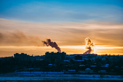 Smoke emitting from chimney against sky at sunset