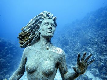 Low angle view of angel statue against clear blue sky