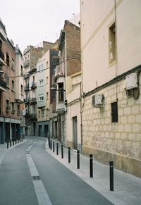 Residential buildings by street against clear sky