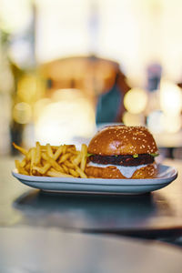 Close-up of burger and french fries in bowl on table