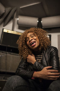 Portrait of young woman sitting on stage