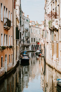 Boats in canal amidst buildings in city